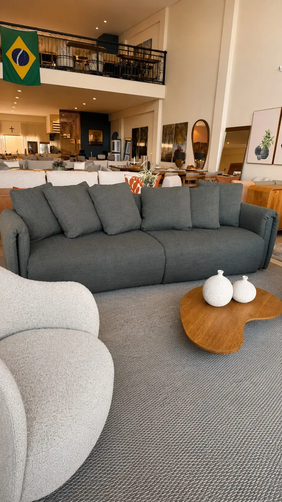Sofá verde em sala ampla com mesa de centro em madeira